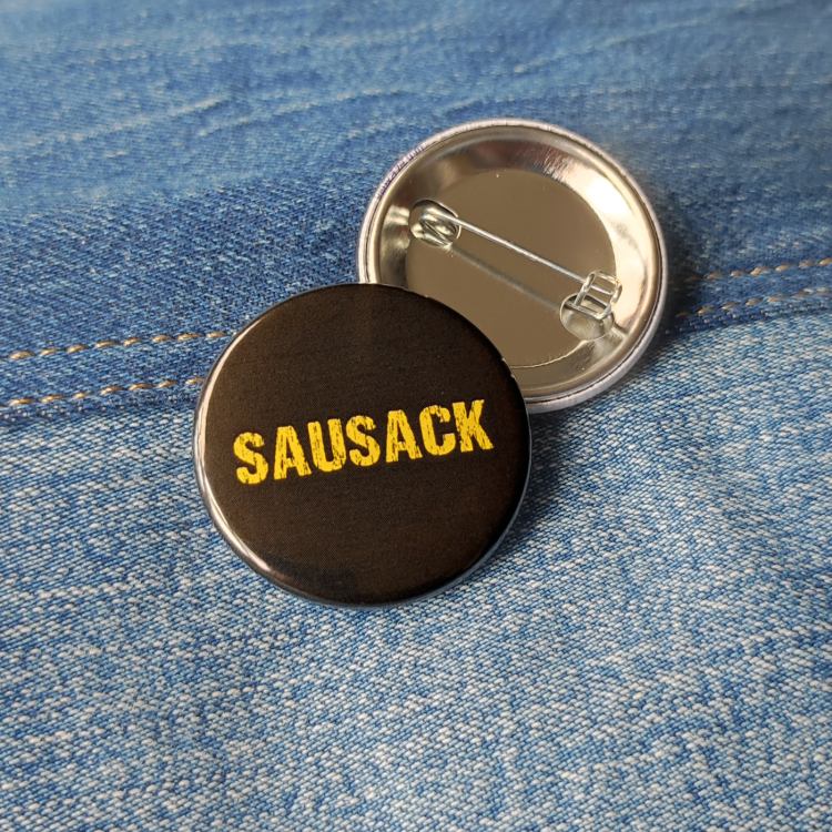 Ansteckbutton Sausack auf Jeans mit Rückseite